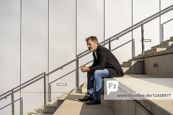 Businessman sitting on steps outdoors relaxing