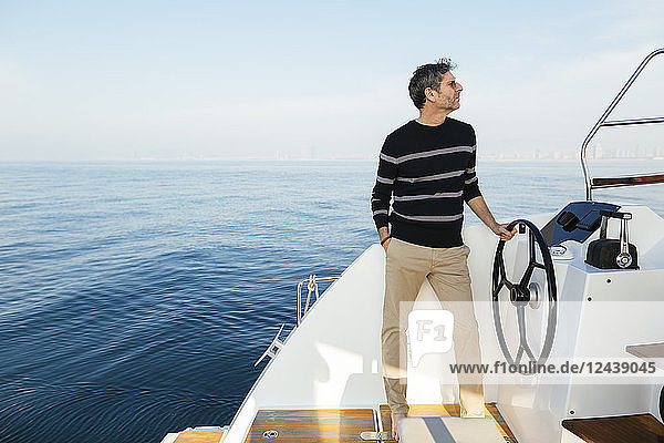 Mature man navigating catamaran on a sailing trip