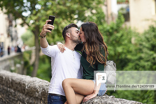 Couple in love in the city kissing and taking a selfie