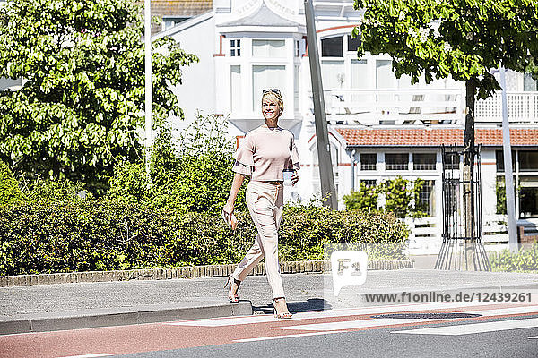 Smiling woman crossing a street