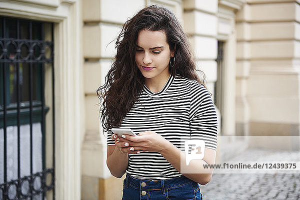 Young woman using cell phone in the city