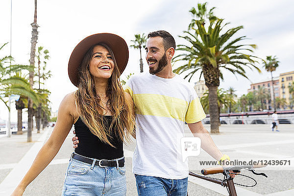 Spain  Barcelona  happy couple walking on seaside promenade