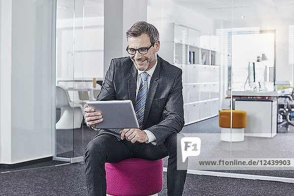 Smiling businessman using tablet in office