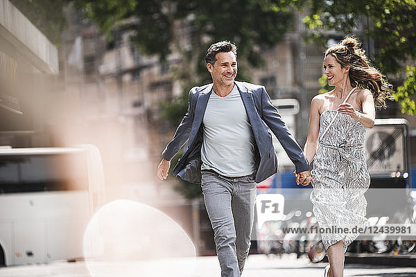 Happy carefree couple running in the city