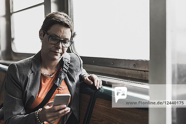 Businesswoman on a ferry looking on cell phone