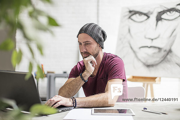 Artist using laptop in studio