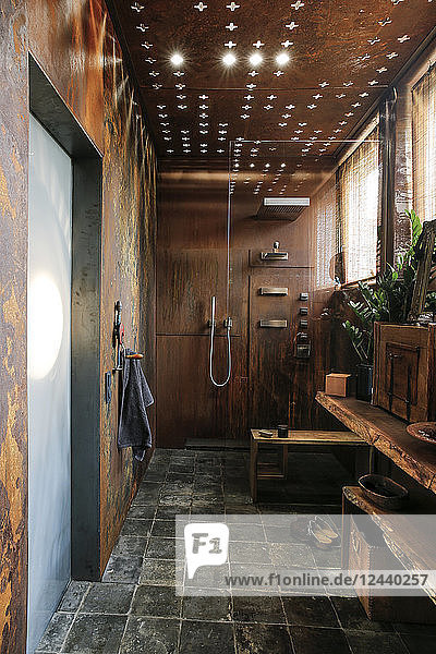 Modern bathroom with corten steel wall cladding and ceiling light effects