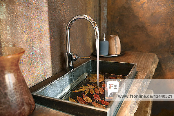 Bathroom sink and stainless steel tap in bathroom with Corten steel wall cladding