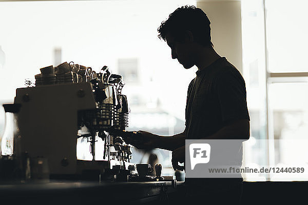Silhouette of Barista preparing coffee in a coffee bar