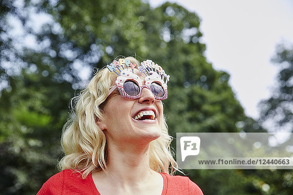 Happy woman wearing birthday eyeglasses
