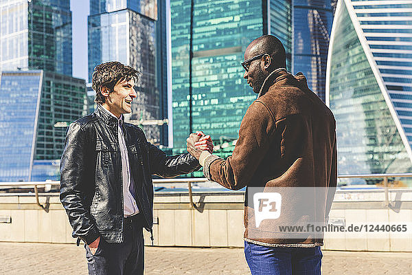 Russia  Moscow  two businessmen in front of modern office buildings