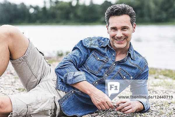 Portrait of smiling man relaxing at the riverside