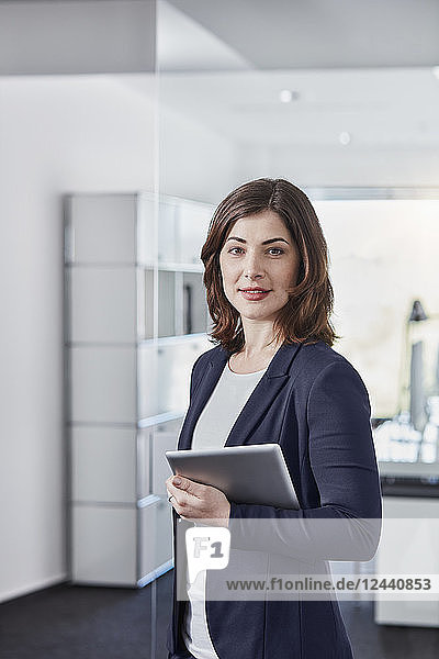 Portrait of smiling young businesswoman with tablet in office