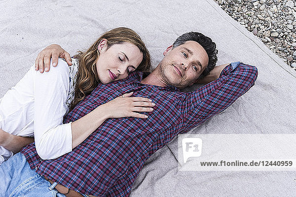 Affectionate couple lying on a blanket