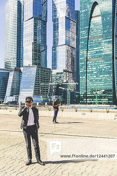 Russia  Moscow  two businessmen using cell phones in the city