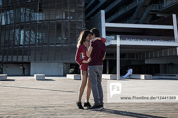 Affectionate young couple standing on city square