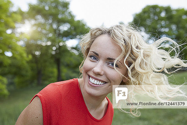 Portrait of smiling blond woman wearing red t-shirt outdoors