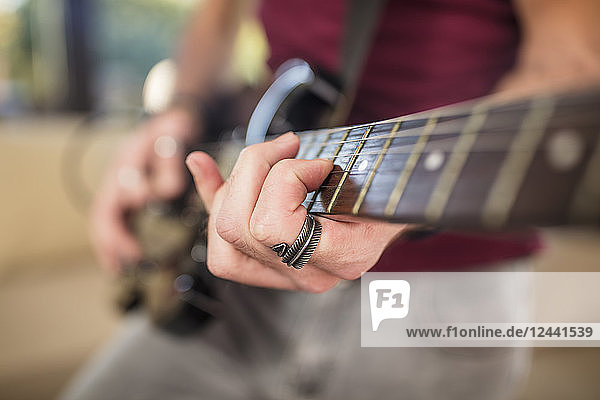 Close-up of man's hand playing electric guitar