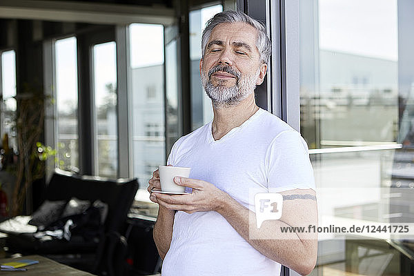 Man standing at French enjoying cup of coffee