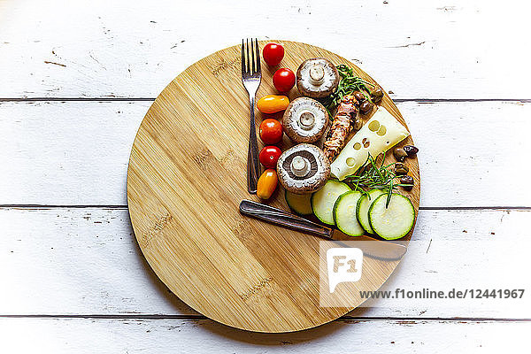 Vegetables on round chopping board  symbol for intermittent fasting