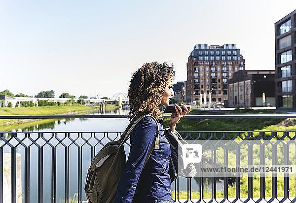 Young businesswoman walking on bridge  talking on the phone