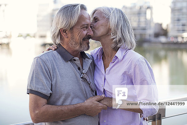 Senior couple taking a city break  kissing and embracing