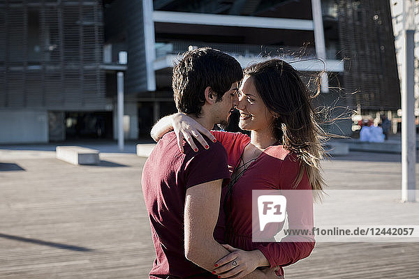 Affectionate young couple standing on city square