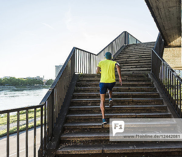 Young athlete jogging up stairs in the city