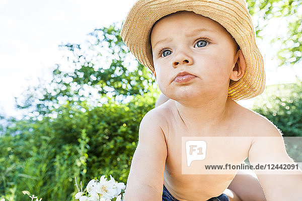 Portrait of shirtless baby boy wearing straw hat