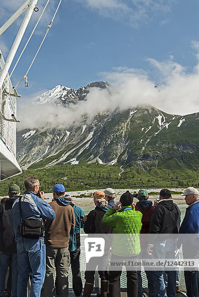 Touristen betrachten die Landschaft vom Deck des Tagesausflugsbootes Baranof Wind der Berge auf der Ostseite der Glacier Bay hinter Russell Island  Glacier Bay National Park  Südost-Alaska; Alaska  Vereinigte Staaten von Amerika