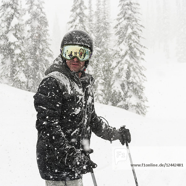 Skier standing in a heavy snowfall at Sun Peaks Resort; Kamloops  British Columbia  Canada