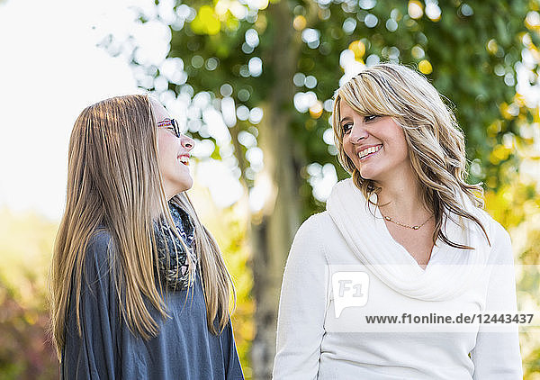 Mutter und Tochter spazieren und lachen zusammen in einem Park im Herbst  Edmonton  Alberta  Kanada