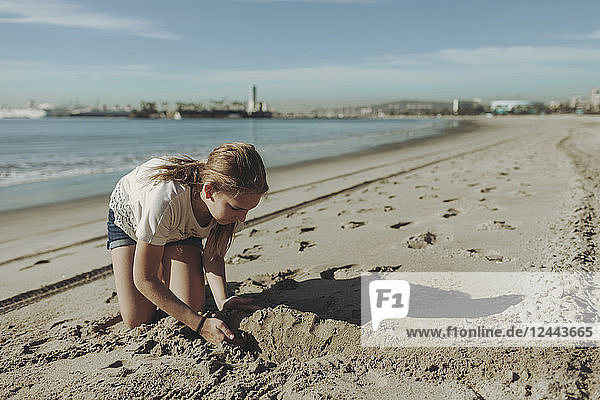 Ein Mädchen spielt im Sand am Strand; Long Beach  Kalifornien  Vereinigte Staaten von Amerika