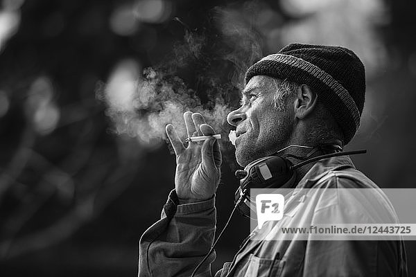 Black and white image of a man smoking a cigarette; Edmonton  Alberta  Canada