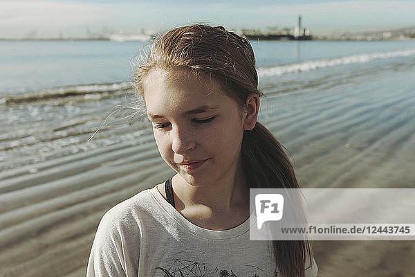 Porträt eines Mädchens am Strand  das mit geschlossenen Augen in der Brandung steht; Long Beach  Kalifornien  Vereinigte Staaten von Amerika