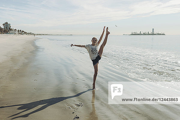 Ein Mädchen in einer Tanzpose am Strand; Long Beach  Kalifornien  Vereinigte Staaten von Amerika