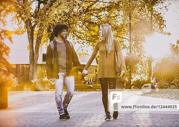 Freund und Freundin beim Spaziergang und Händchenhalten auf dem Universitätscampus bei Sonnenuntergang  Edmonton  Alberta  Kanada