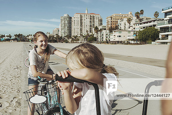 Schwestern fahren mit dem Fahrrad am Strand von Long Beach entlang; Los Angeles  Kalifornien  Vereinigte Staaten von Amerika