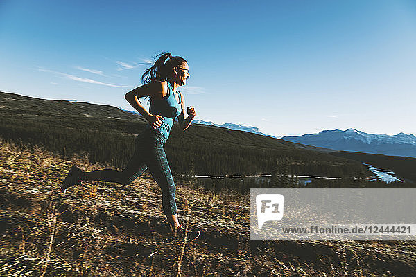 A woman running on a trail in the Rocky Mountains  near Hinton; Alberta  Canada