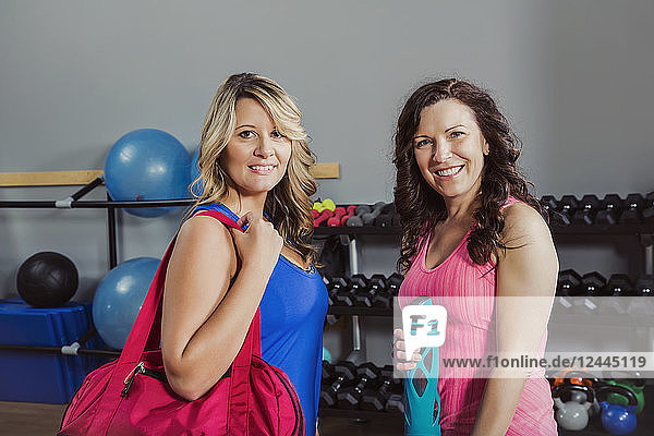 Zwei attraktive Frauen mittleren Alters posieren für die Kamera nach einem Fitnesskurs in einem Fitnessstudio  Spruce Grove  Alberta  Kanada