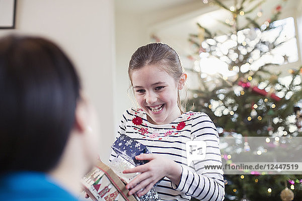 Glückliches  eifriges Mädchen beim Sammeln von Weihnachtsgeschenken