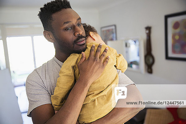 Zärtlicher Vater hält müden Babysohn