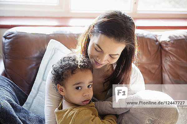 Mother and innocent baby son on living room sofa
