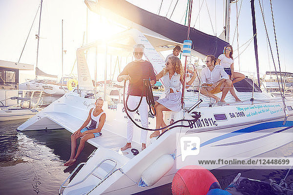 Friends relaxing on catamaran ins sunny harbor