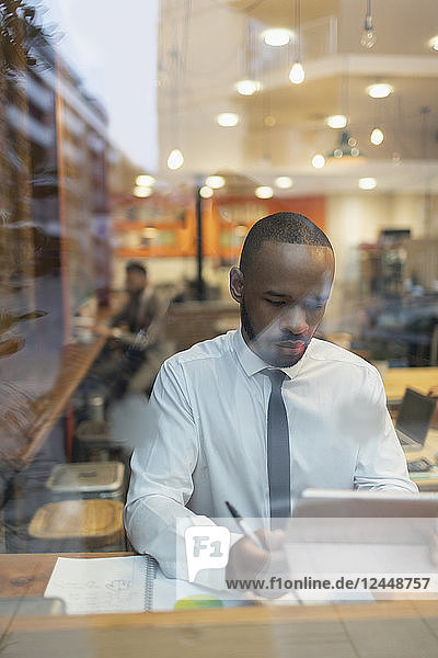 Businessman using digital tablet  working in cafe window