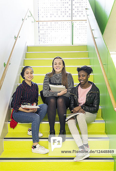 Portrait smiling  confident high school girls sitting on stairs