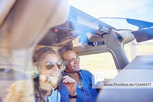 Happy pilot and copilot couple flying airplane