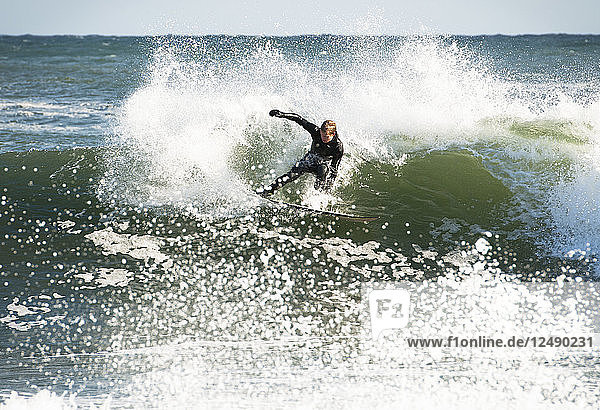 Surfer riding wave in sea
