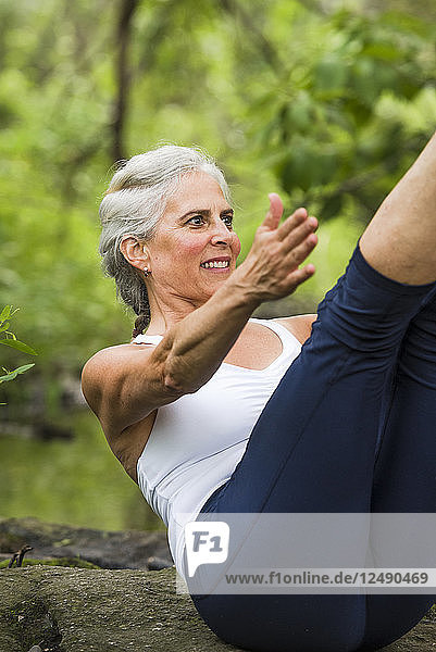 Ältere Frau macht Yoga im Wald