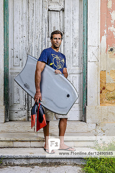 Porträt eines Bodyboarders an einem verlassenen Ort in Portugal